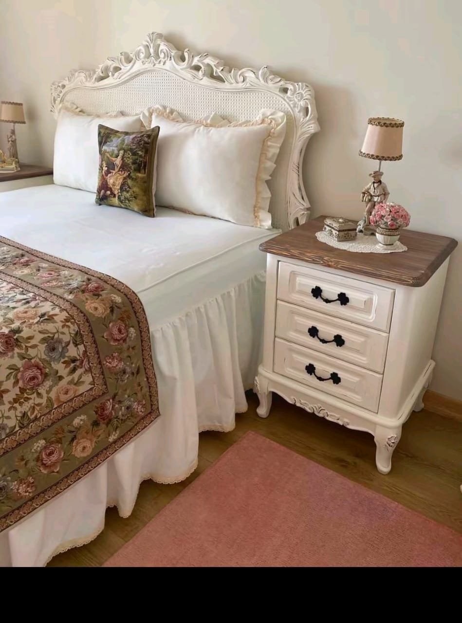 A bedroom with a padded bed and bedside lamps